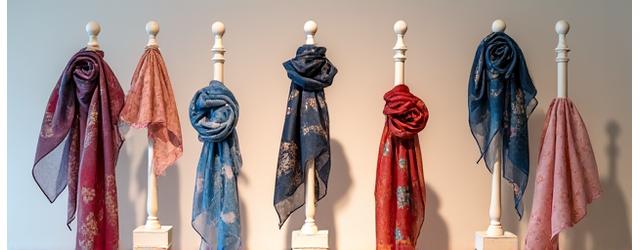 Produktfotografi av en limited edition skjerfkolleksjon med håndtrykte kunstmotiver, elegant presentert på en butikkutstilling